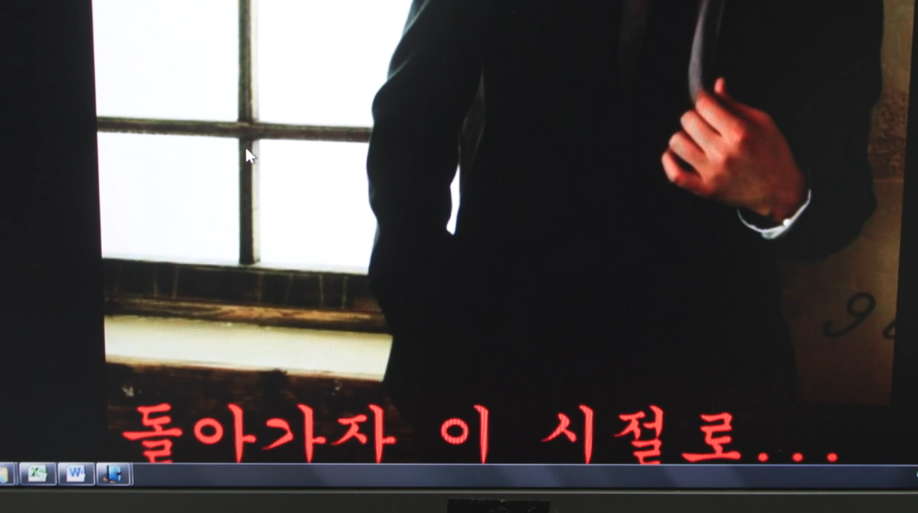 기봉권 교사의 컴퓨터 바탕 화면. 정장을 입은 남자의 사진 위에 궁서체의 빨간색 글씨로 '돌아가자 이 시절로...'라고 적혀 있음.